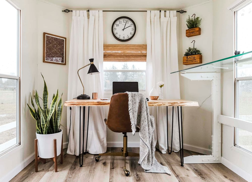 Home office with throw blanket on leather office chair in front of a wood desk