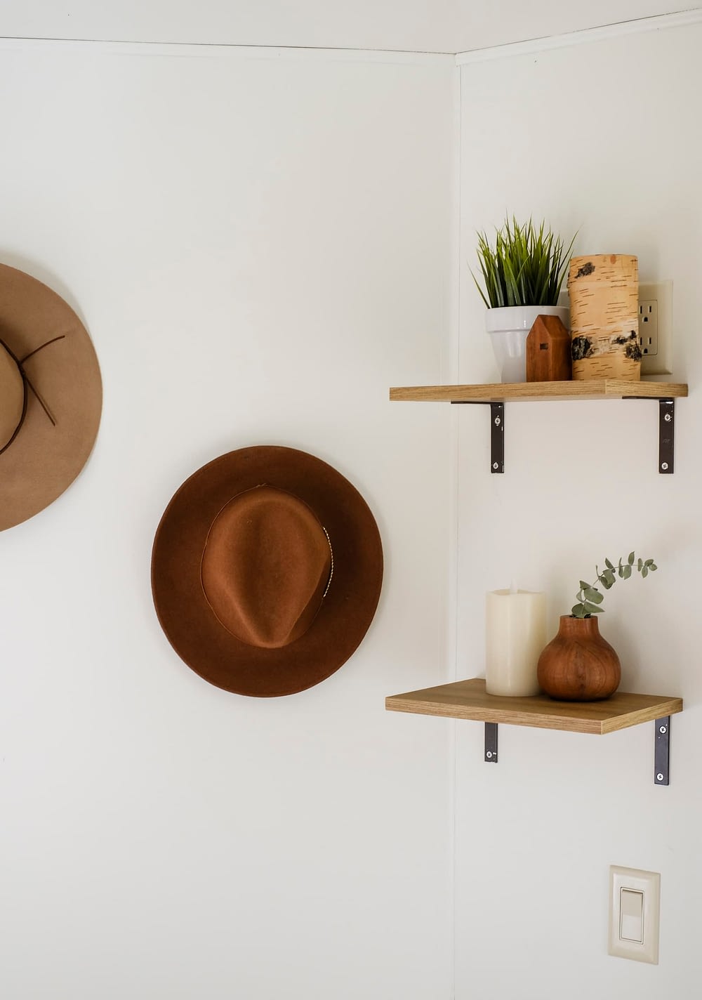 Open shelving on the wall and hats hung on a hook