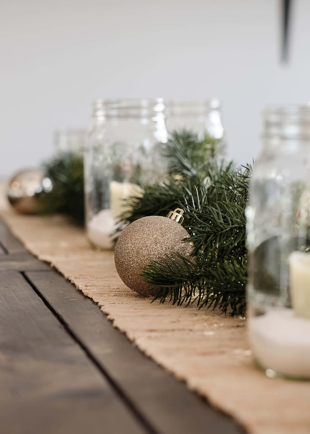christmas dining table centerpiece with mason jar candle holders and ornaments