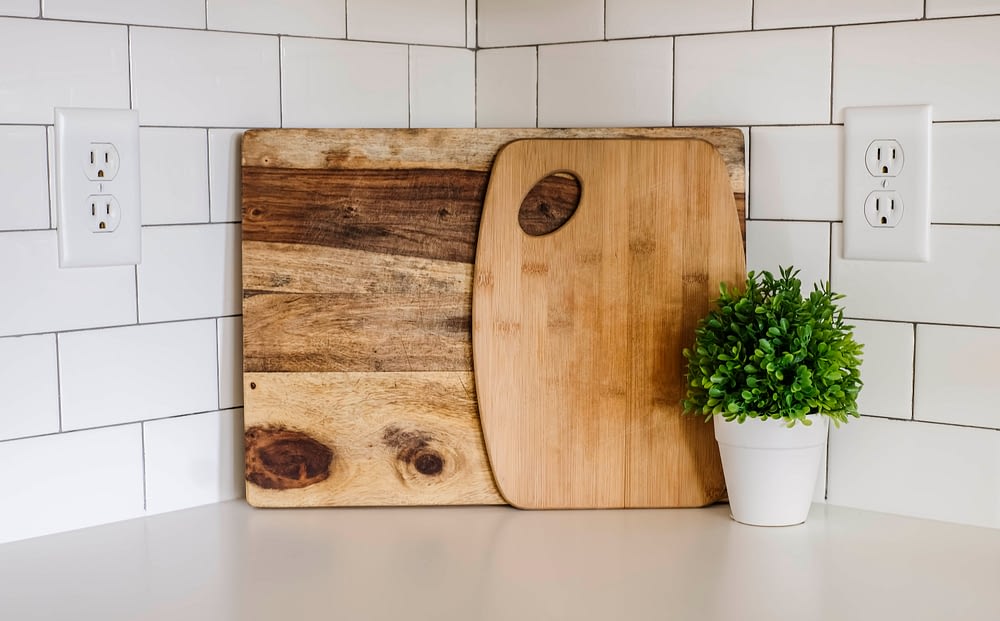 wood cutting boards leaned against white subway tile back splash 