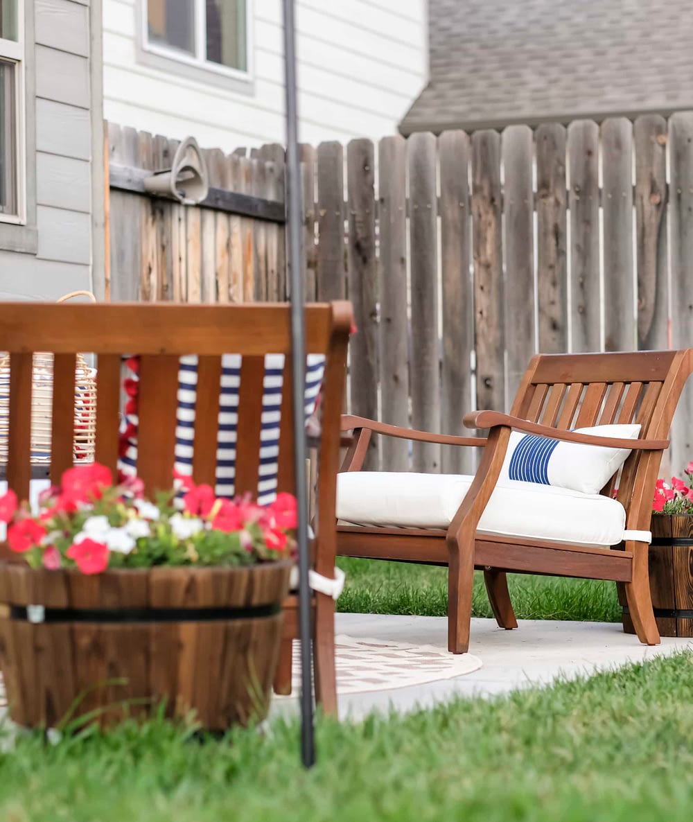 outdoor patio with flowers in barrels and wood lawn chairs