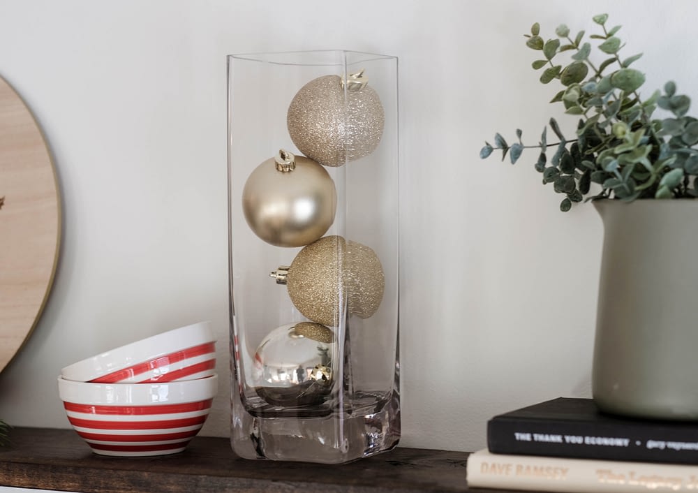 Christmas decor idea using a vase filled with christmas ornaments