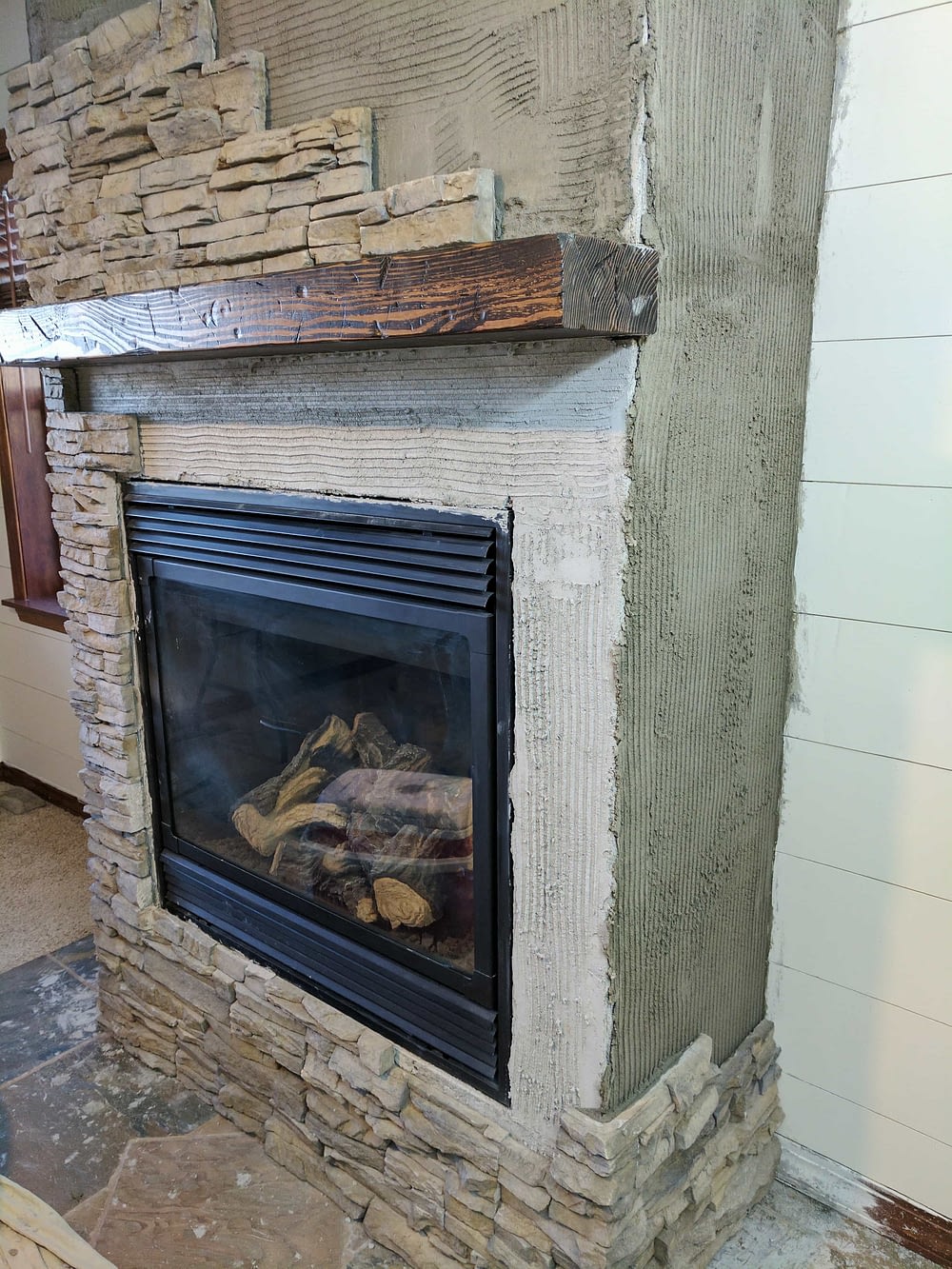 installing stone veneer on a fireplace for a remodel 