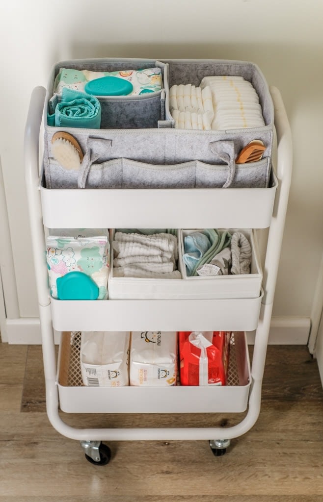 closeup of three tier utility cart with baby diapers, wipes and other supplies organized 