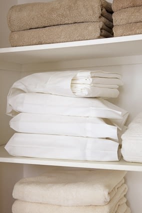 A stack of bedsheets folded up separately and stored inside of its corresponding pillowcase