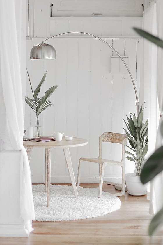 coastal style decor with white walls, bleached wood furniture and beachy greenery