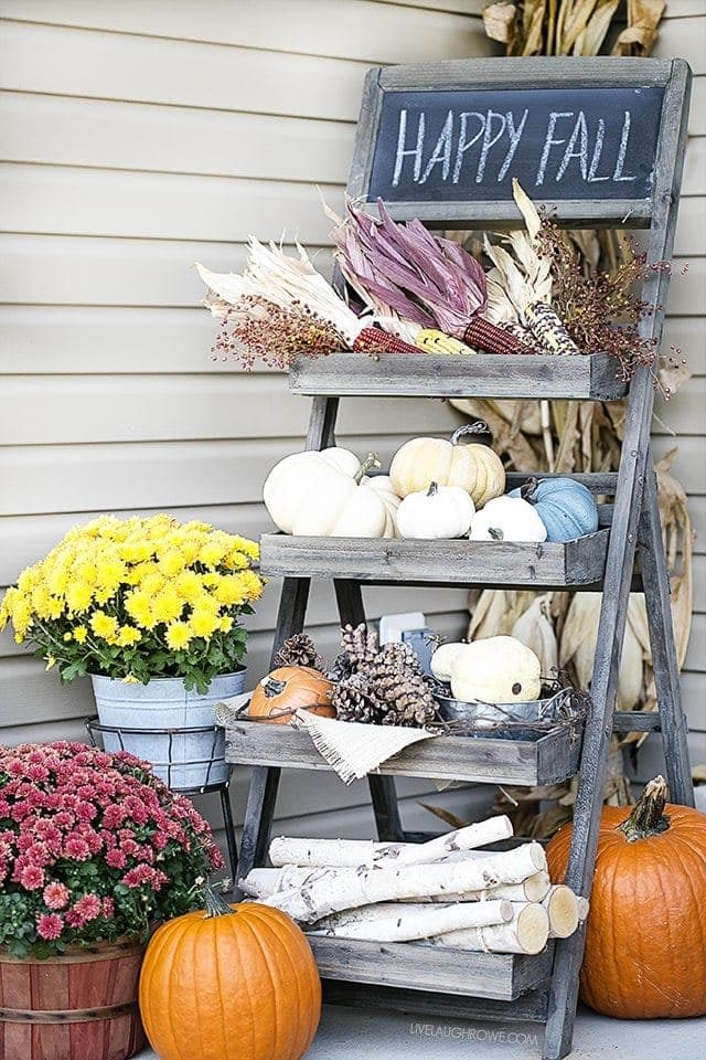 Fall front porch ideas using a tiered wood shelf and pumpkins