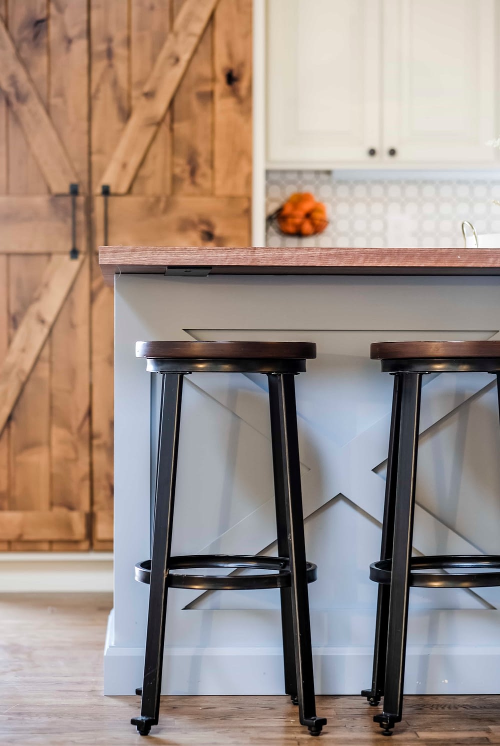 Rustic bar stools in front of a blue kitchen island
