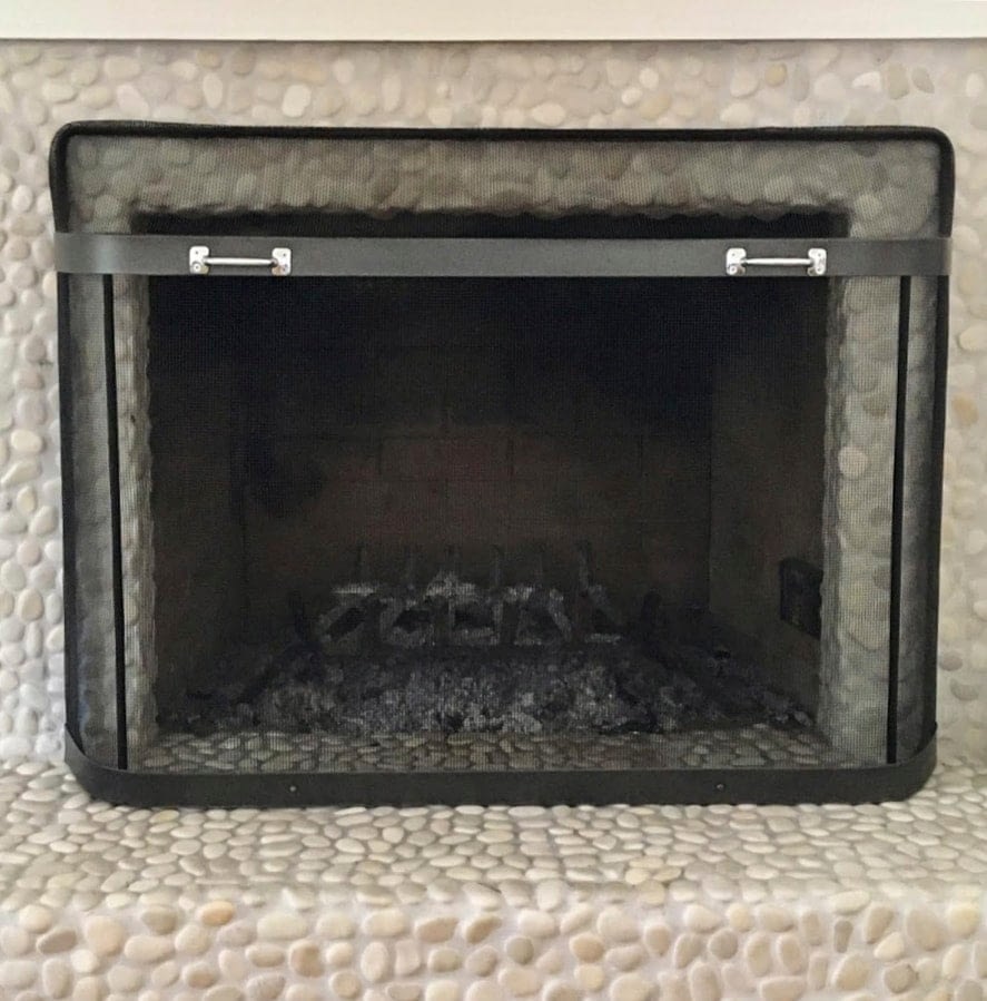 empty fireplace with metal screen cover