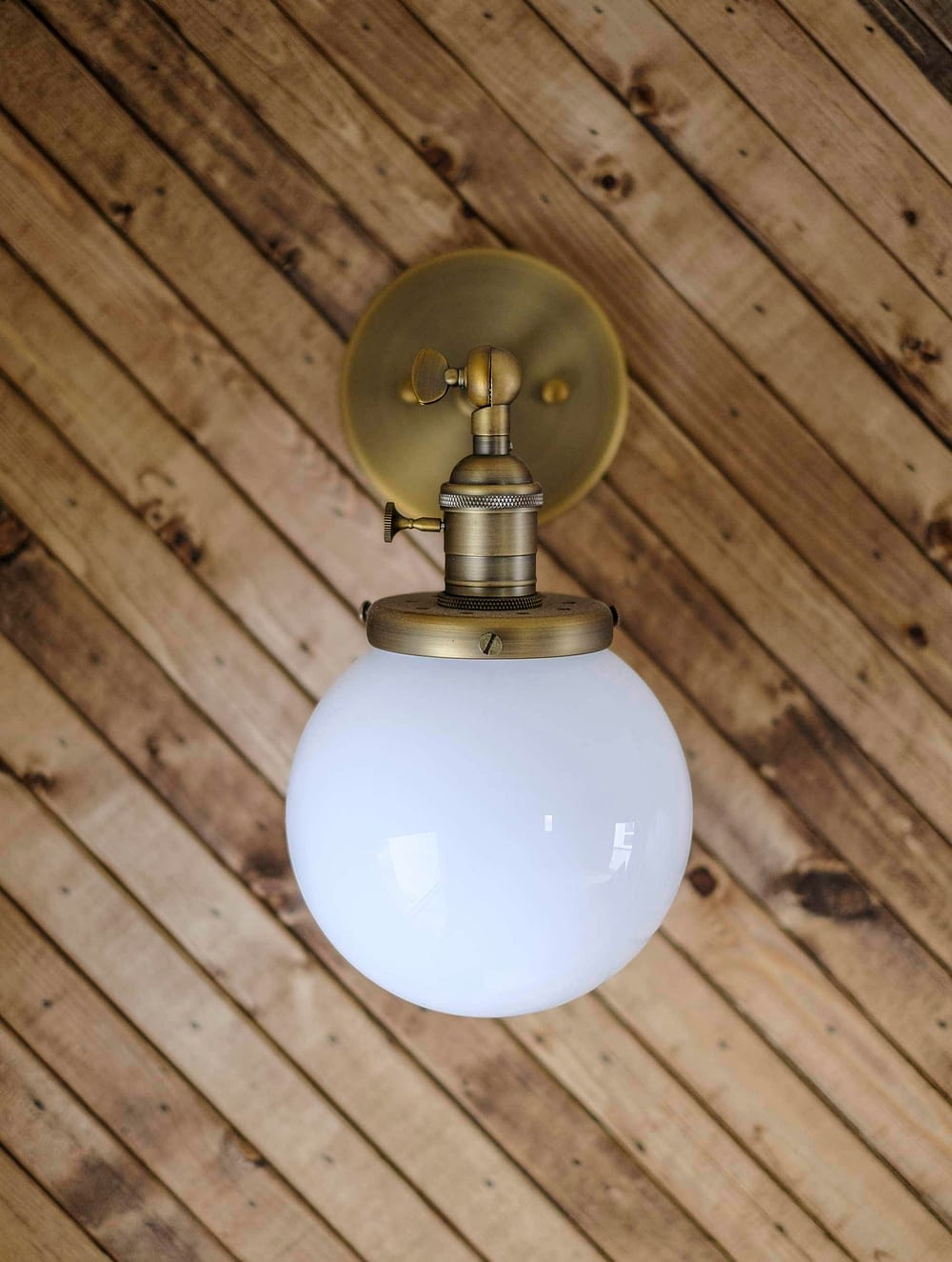 Brass wall sconce with globe light shade