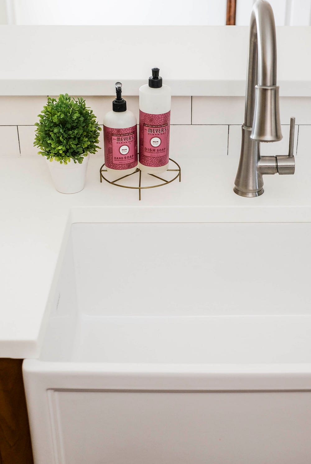 White fireclay farmhouse sink with a closeup on dish soap used to keep it clean