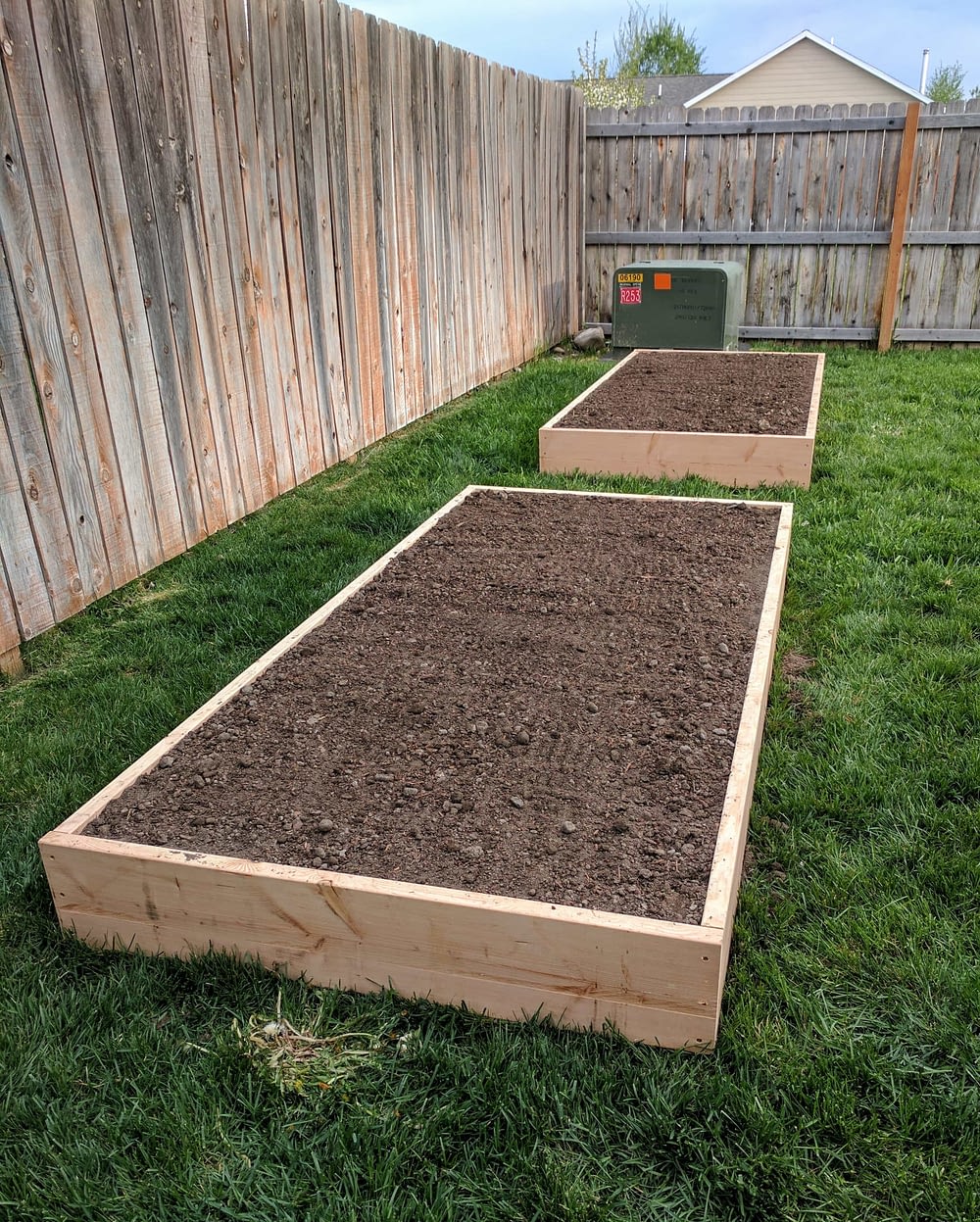 Two raised garden beds full of soil ready to be planted