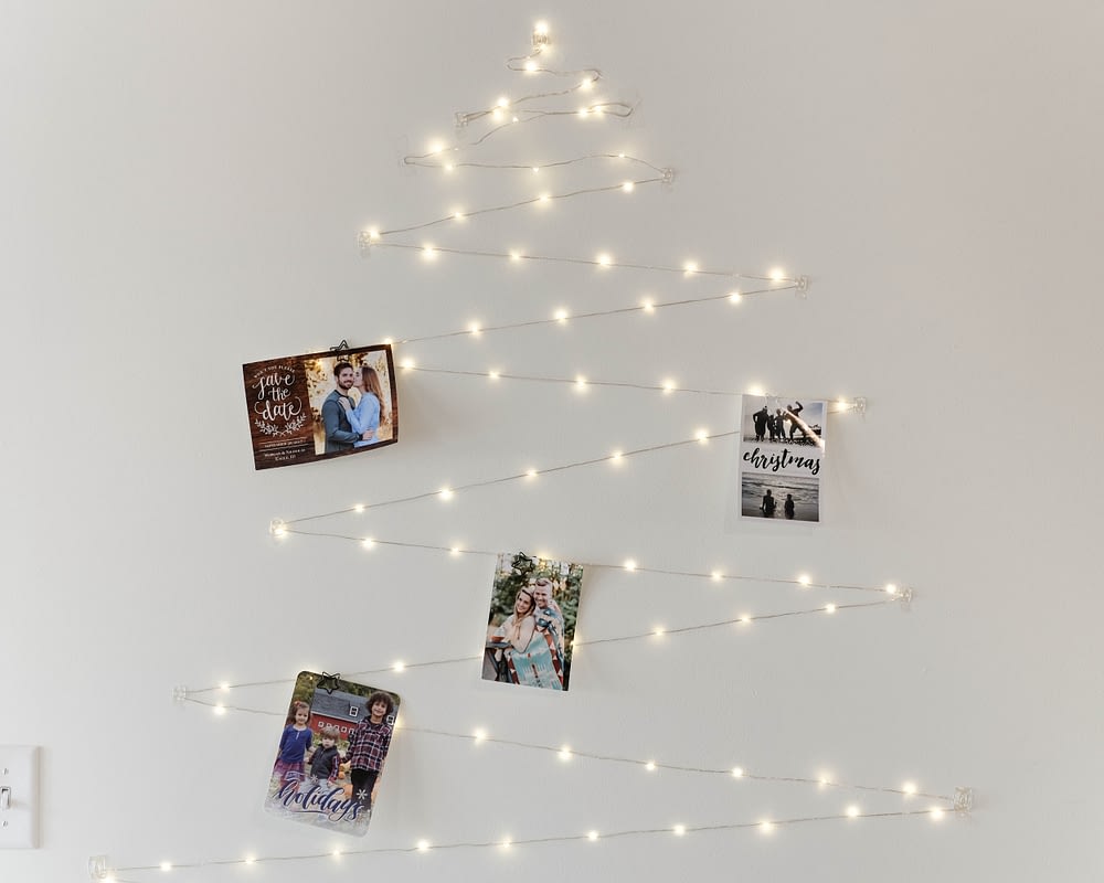Christmas decor ideas using twinkle lights in the shape of a tree with holiday cards