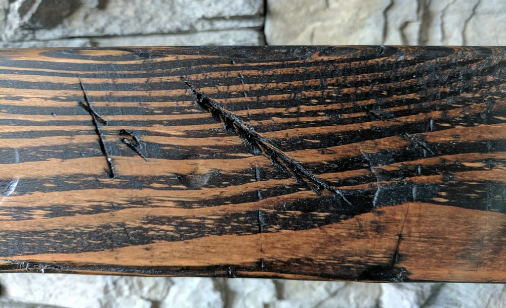 close up of a distressed wood beam mantle