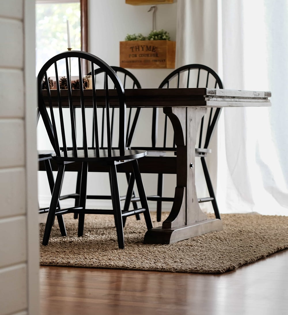 dining room with table and chairs on top of a jute rug