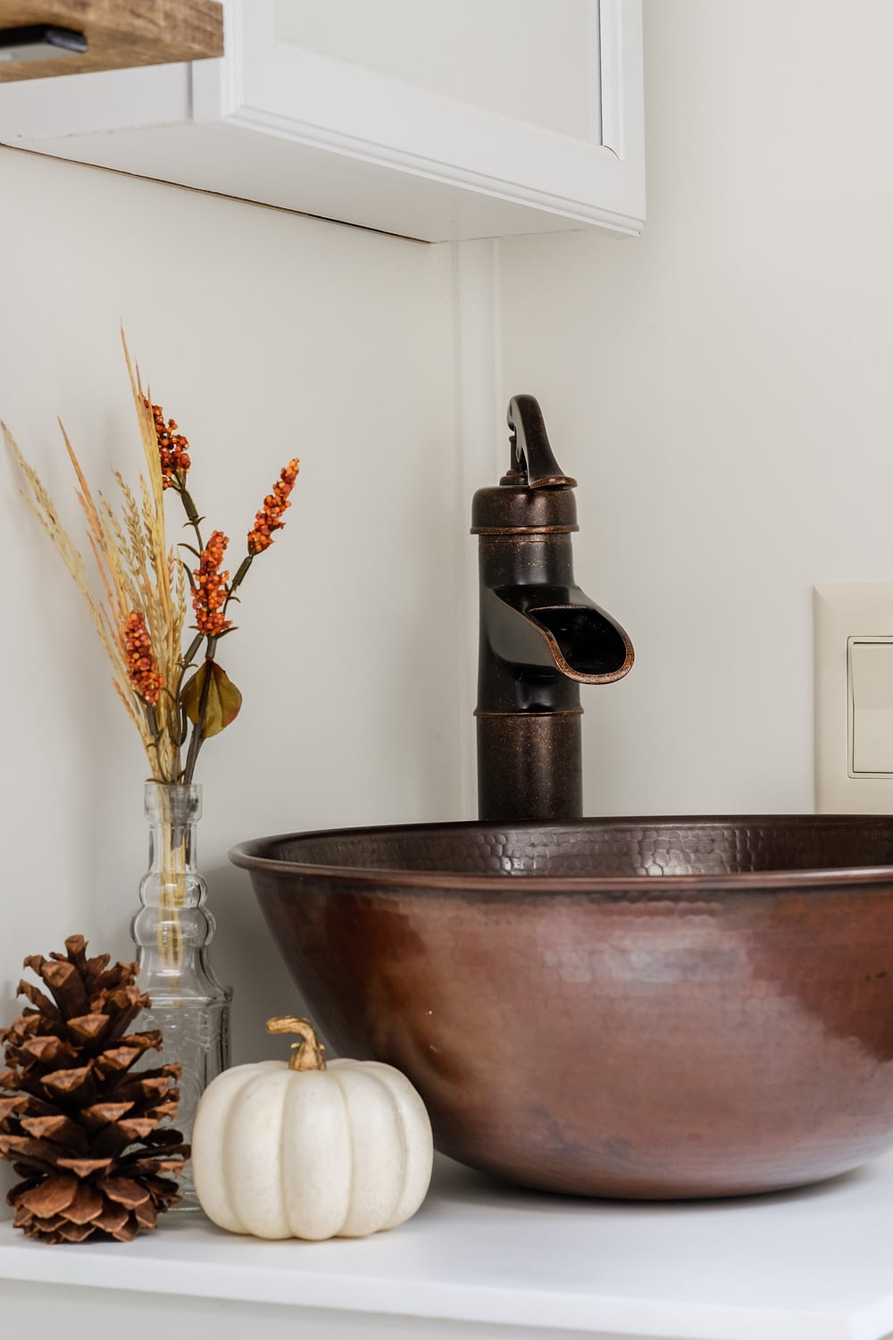 RV bathroom remodel decorated for fall with copper fixtures and mini pumpkins