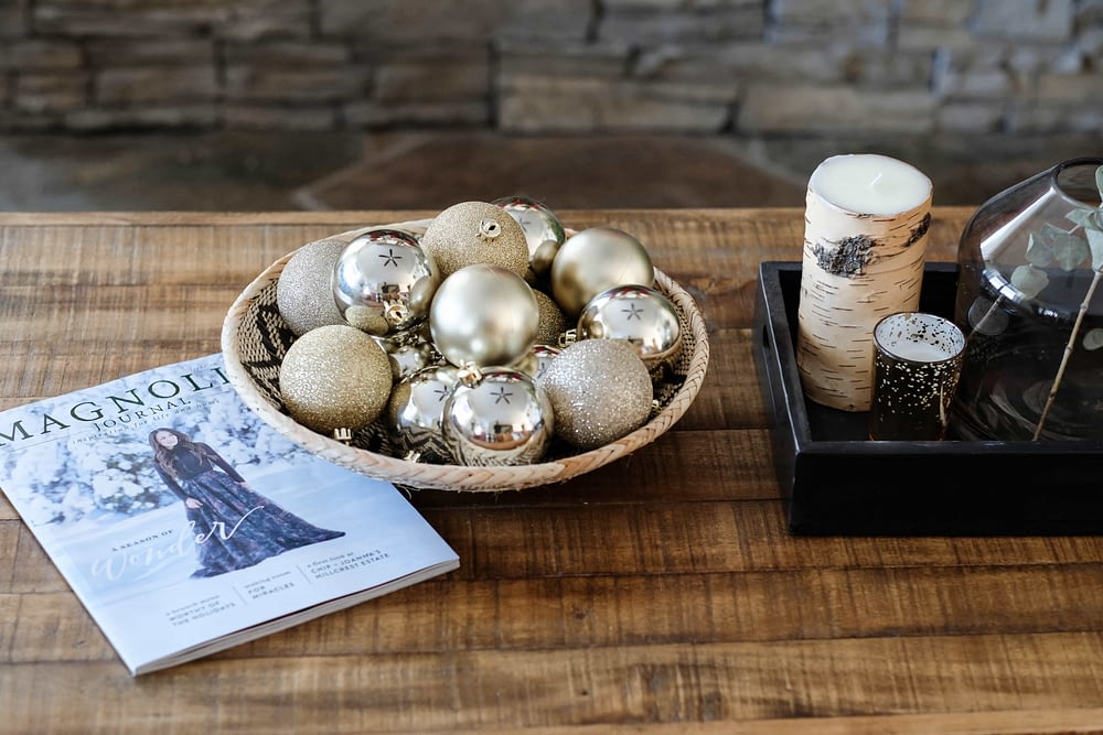 christmas decor idea on the coffee table with bowl full of ornaments and magnolia journal