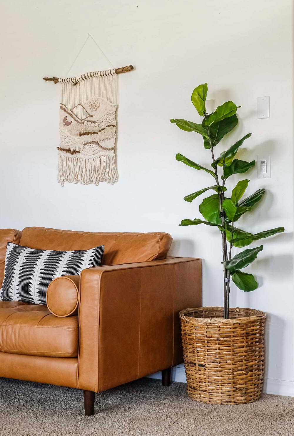 faux fiddle leaf fig tree in a woven basket sitting in a living room