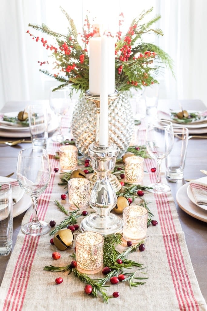 Christmas table centerpiece with votive candles and red striped runner