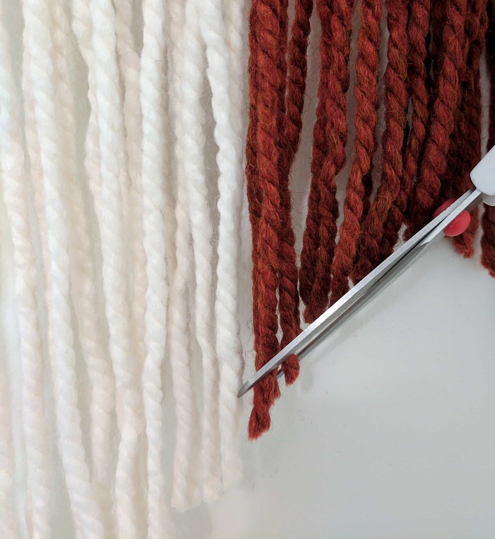 cutting the wall hanging yarn with scissors 
