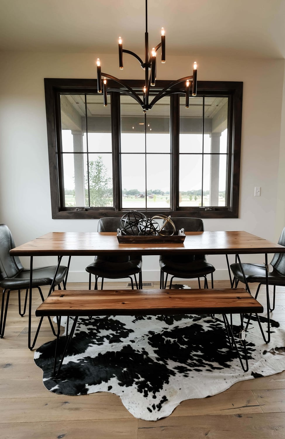 Parade of Homes dining room with wood table, and cowhide rug underneath 