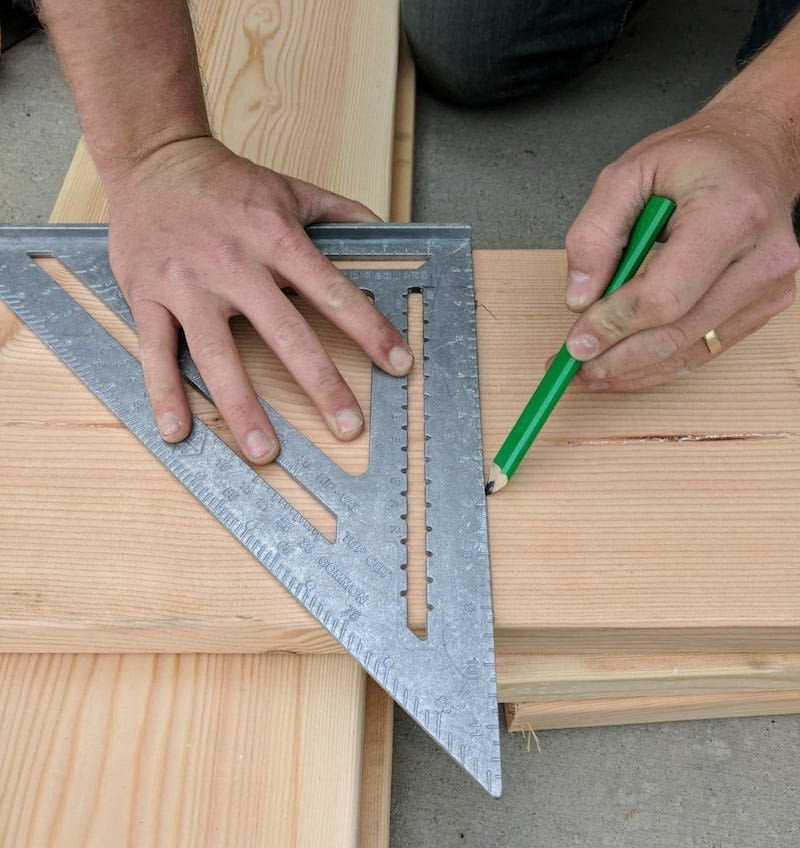 using a speed square to mark lumber with a carpenter pencil