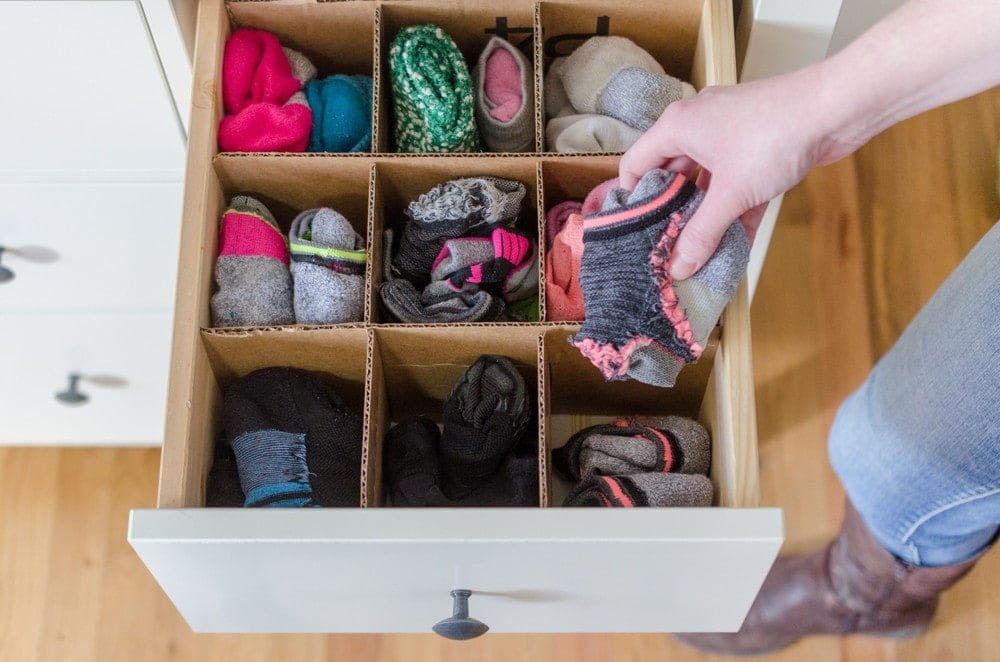 Cardboard cut into strips and placed in a grid pattern being used as sock organization in a drawer