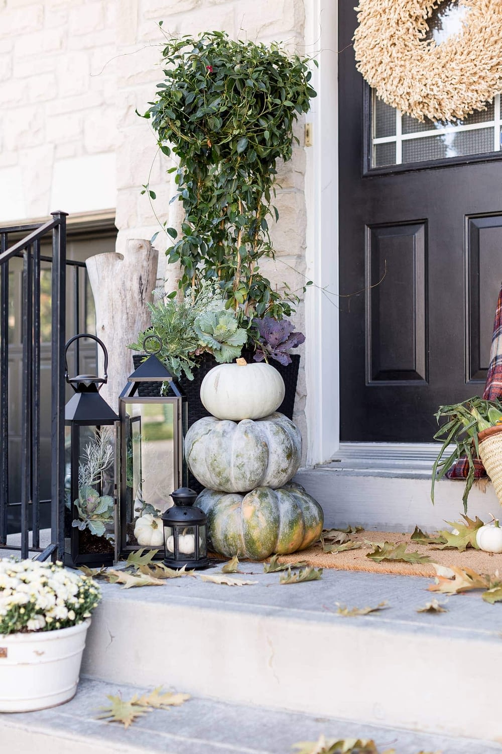 Fall front porch ideas using black lanterns and stacked pumpkins