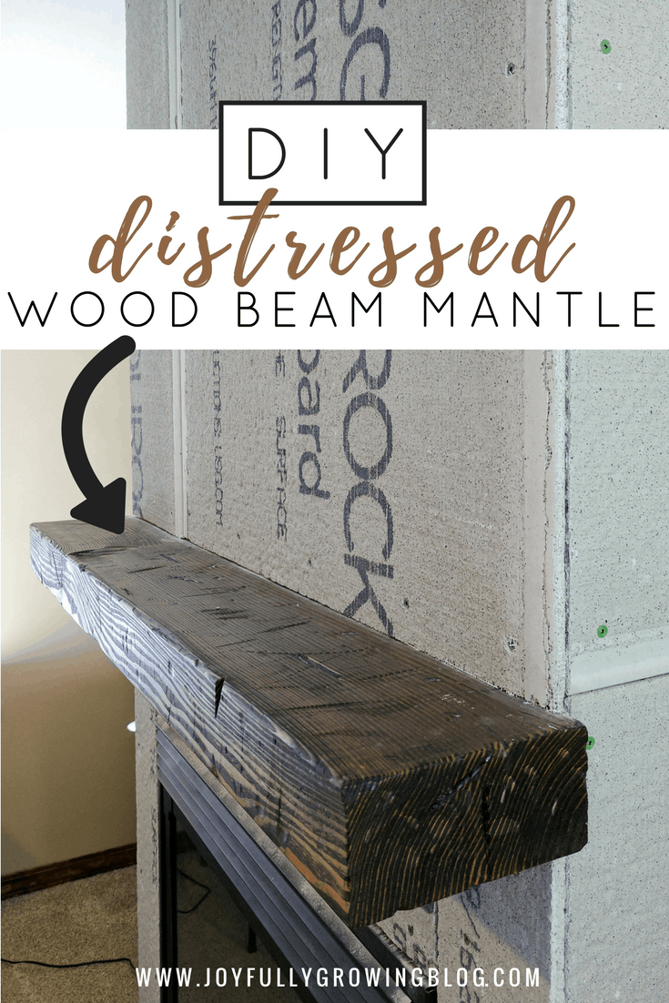 a distressed wood beam mantle hung on an unfinished fireplace