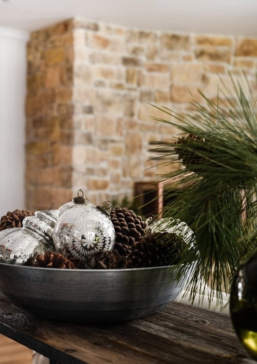 minimalist christmas decorations using ornaments and pine cones in a bowl