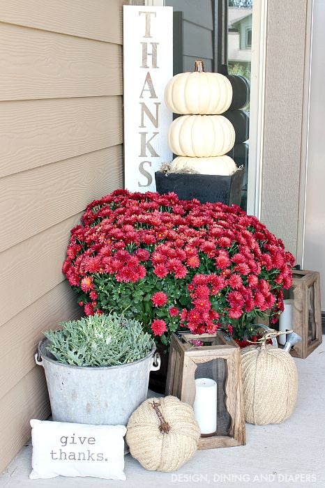 Fall front porch ideas using red mums, wood lanterns and stacking white pumpkins