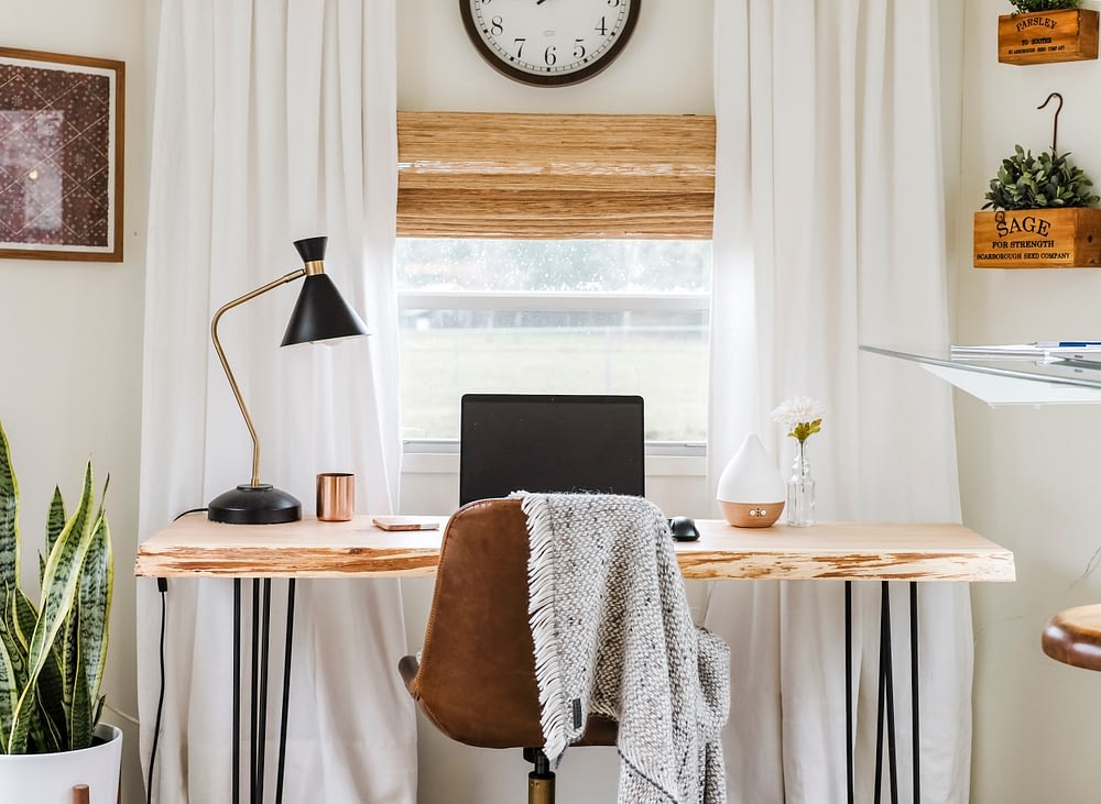 Home office inspiration with wood desk, leather chair and white curtains