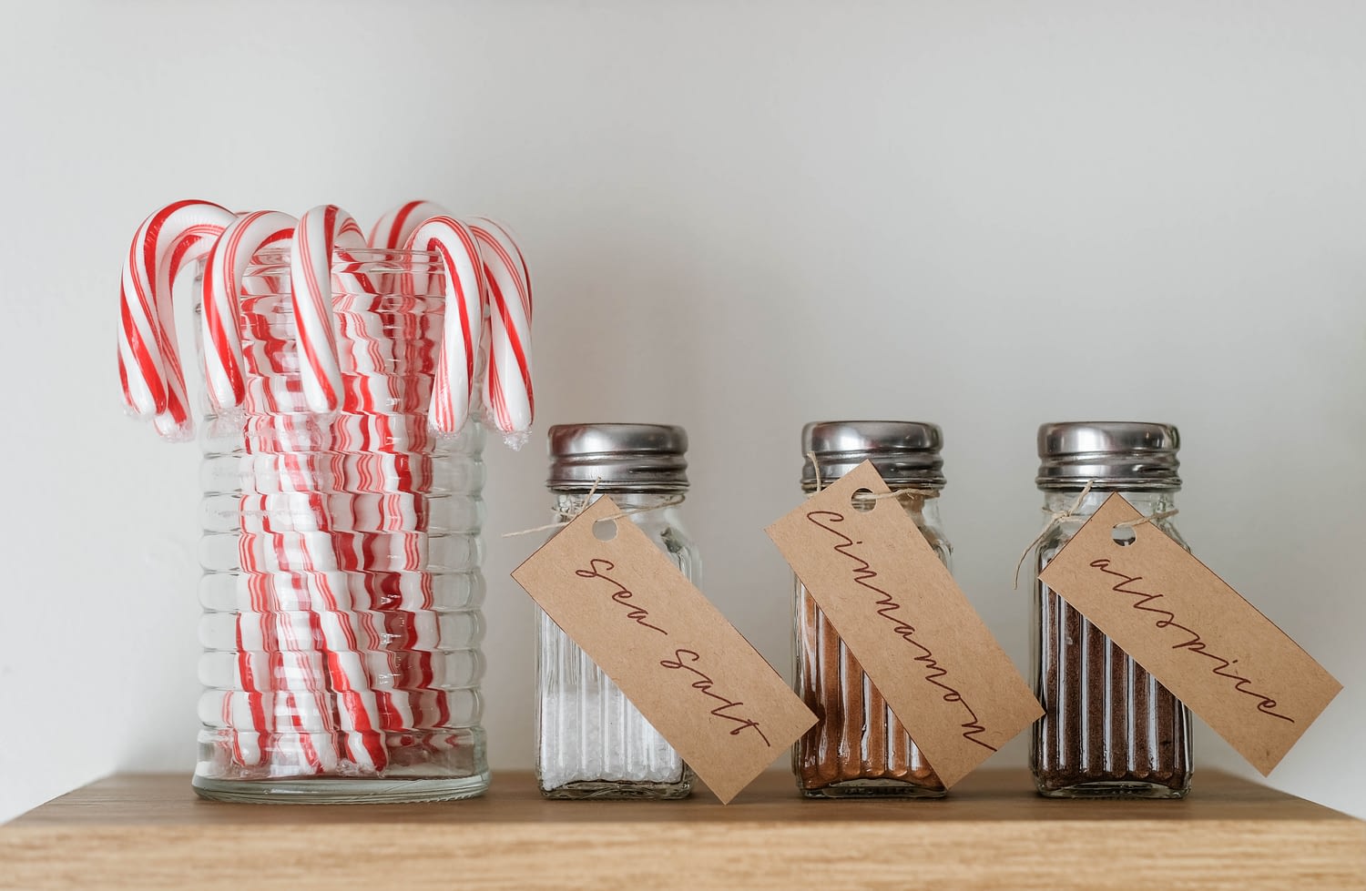 Candy Canes in a jar with shakers of sea salt, cinnamon, and allspice