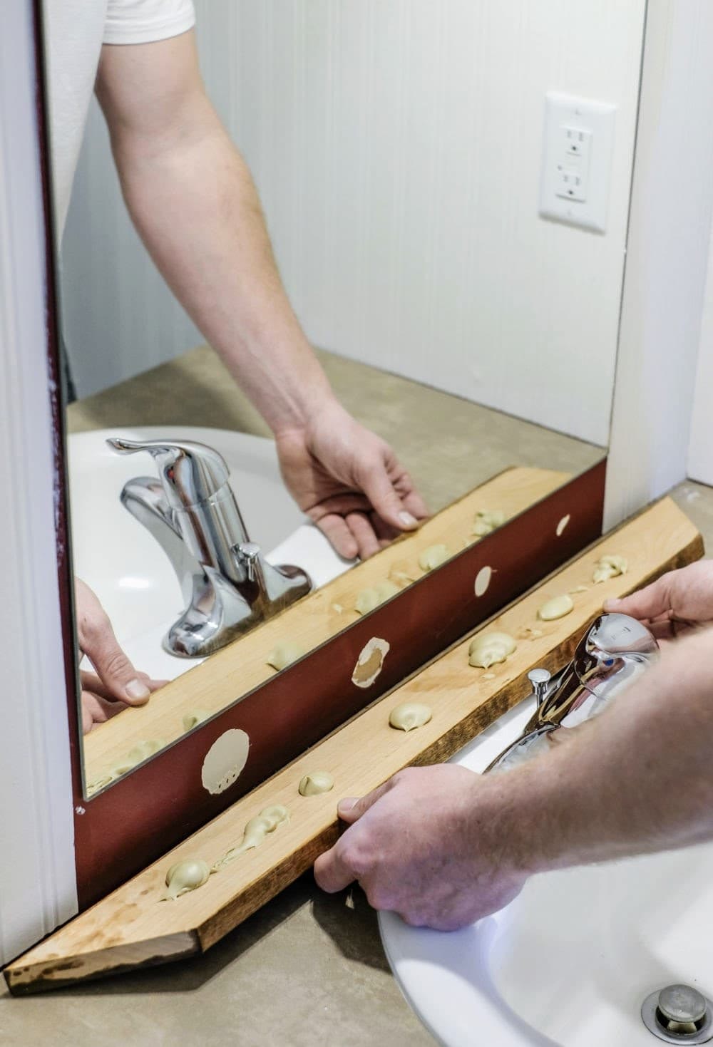installing wood trim around a bathroom mirror